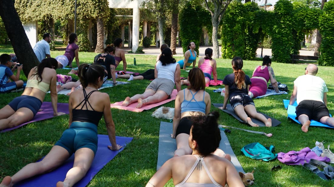 Clase de yoga al aire libre sobre el césped del Jardín del Turia
